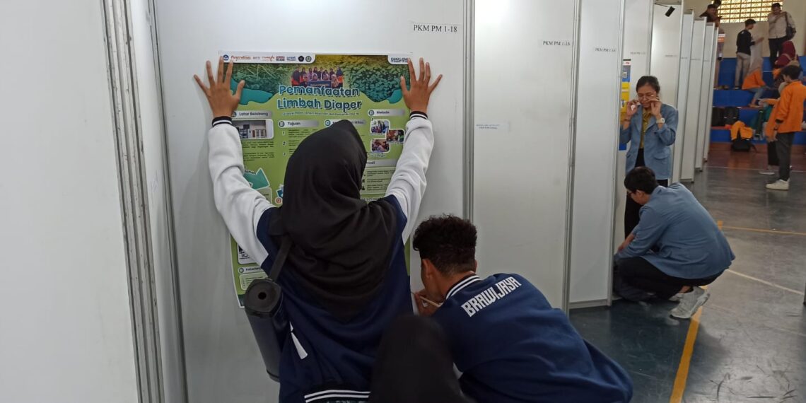 Usai Registrasi, Tim Pimnas UB Pasang Poster PKM PIMNAS